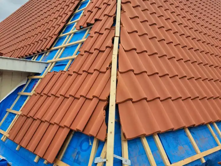Werkfase waarin dakpannen worden aangebracht boven de zichtbare onderdakfolie en panlatten