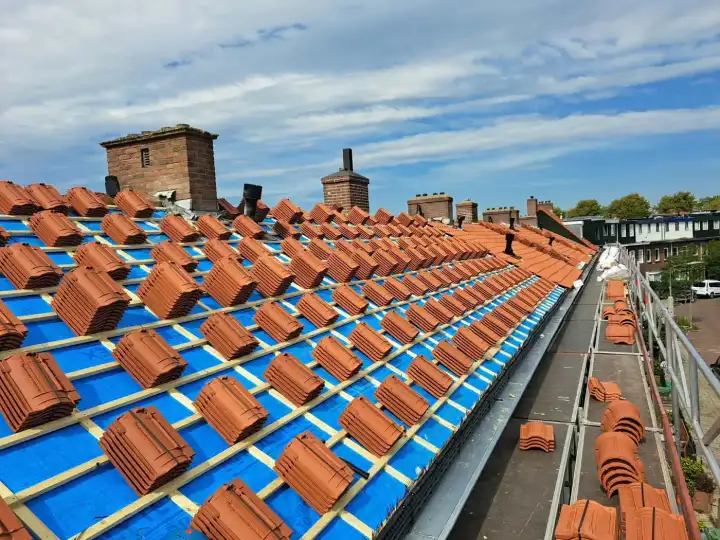 Pannendak tijdens de renovatie met onderdakfolie, tengels, panlatten en gestapelde dakpannen